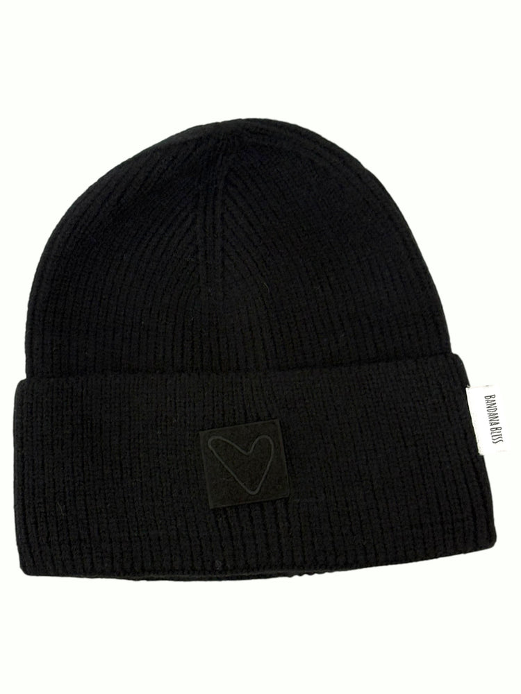 Black Sherpa Heart Beanie laid flat, ribbed cuffed knit with a tonal heart patch
