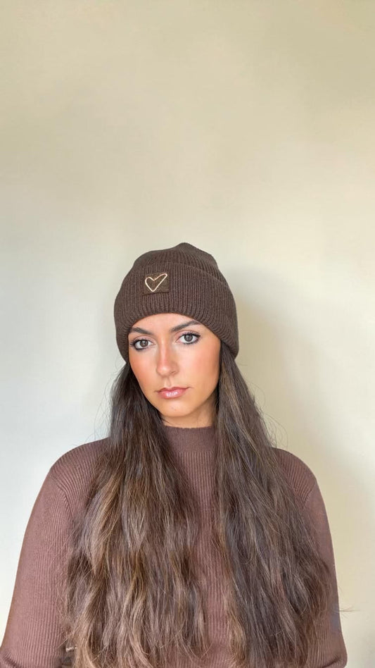 Woman with long hair wearing the cocoa brown Sherpa Heart Beanie with a heart patch on the cuff